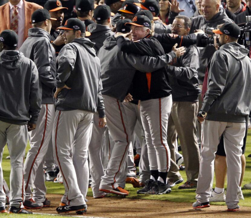 Baltimore Orioles manager Buck Showalter (26) celebrates with teammates after defeating the...