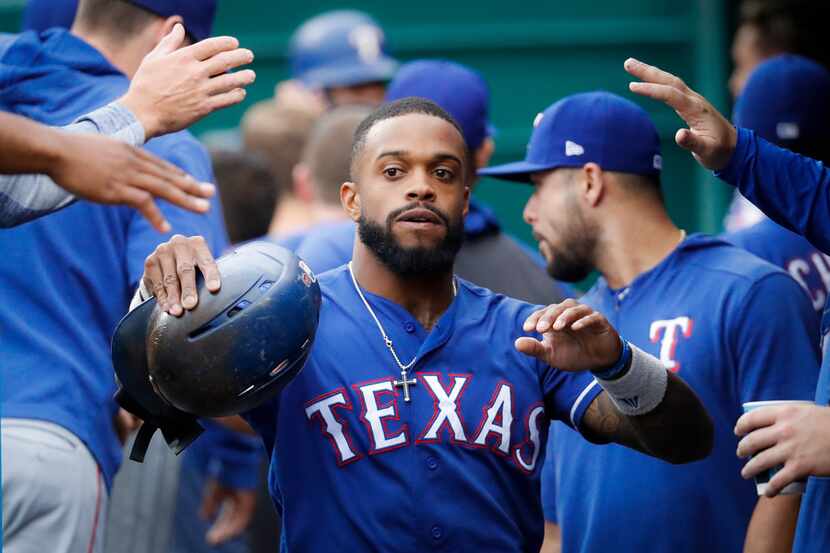 Texas Rangers' Delino DeShields celebrates in the dugout after scoring in the first inning...