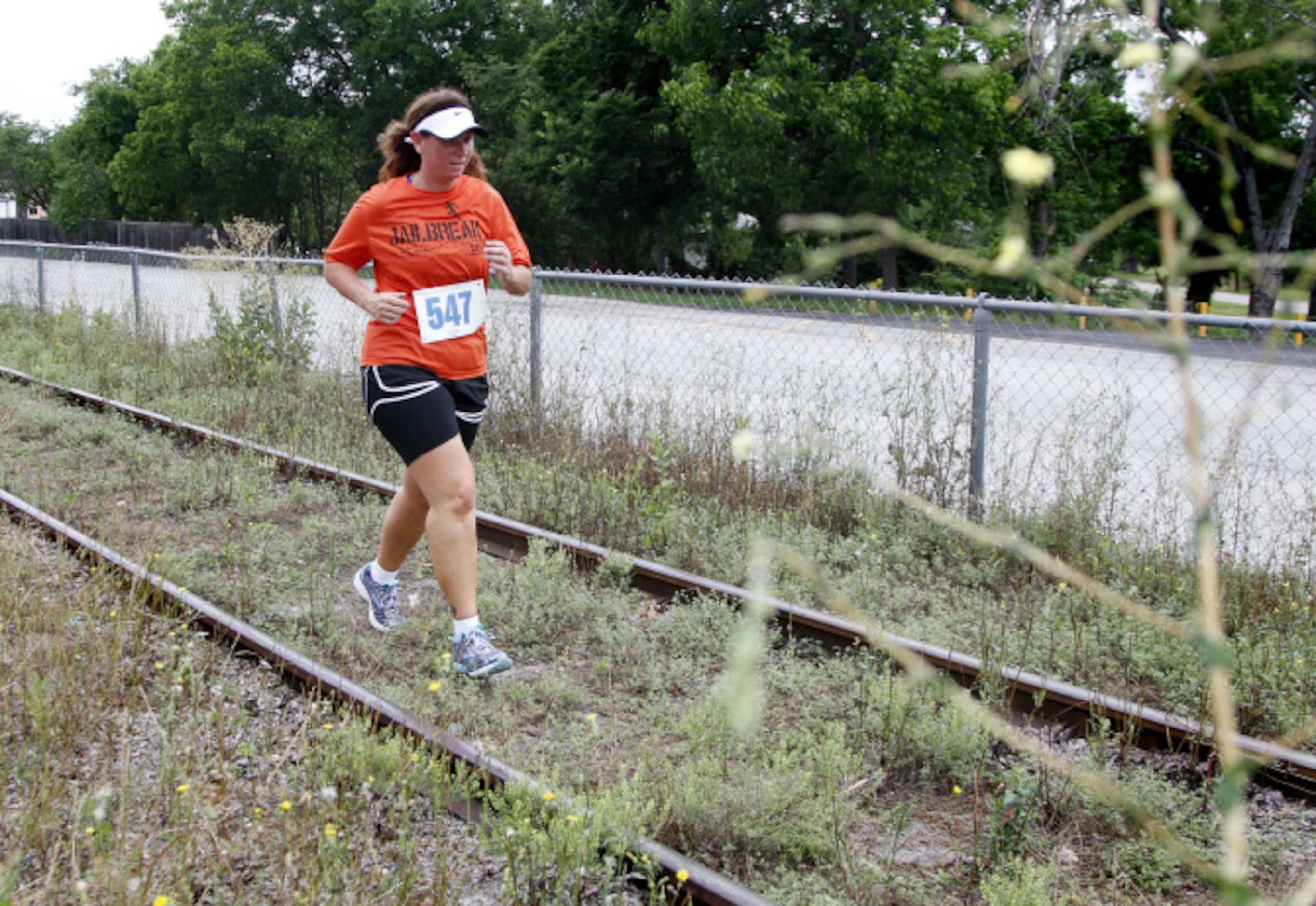 Darla Parnell runs down old train tracks during the Second Annual Fair Park 5K Urban Dash...