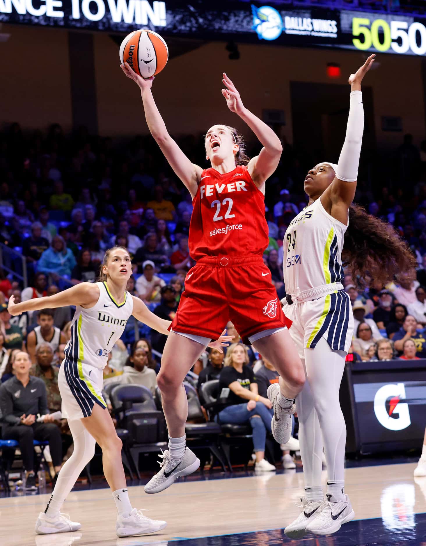 Indiana Fever guard Caitlin Clark (22) lays up a shot and is fouled by Dallas Wings guard...