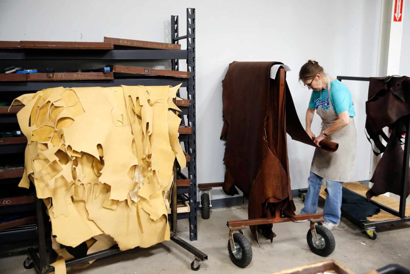 Kennie Watkins rolls up leather to be cut to make baseball gloves at the Nokona factory.