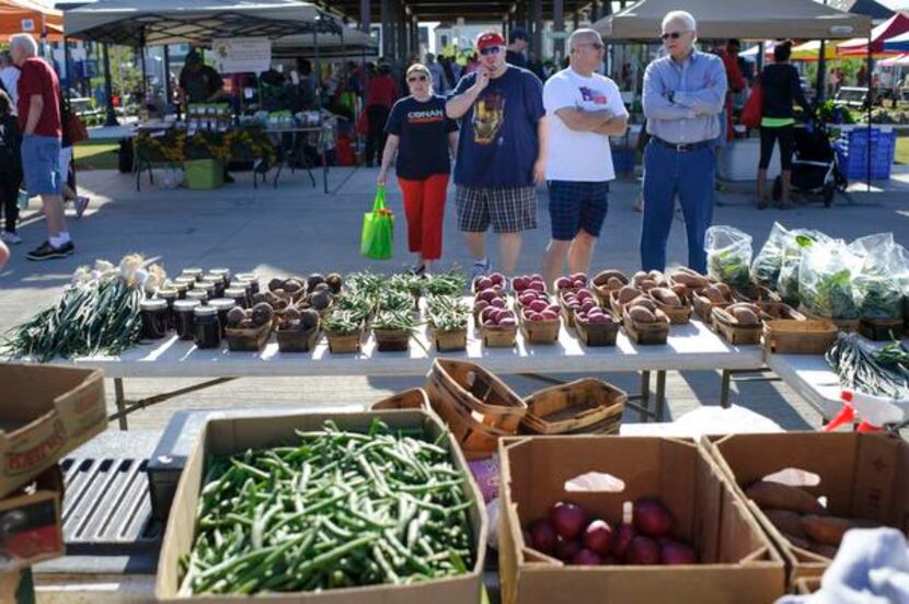 
Customers eye Stacy Finley's display of vegetables during the Coppell Farmers Market.
