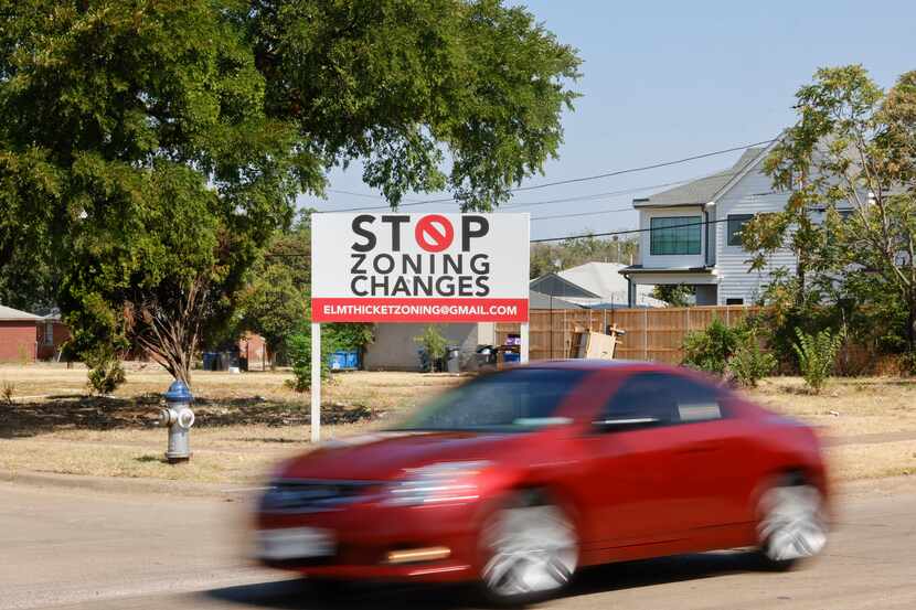 Traffic pass by a sign displaying words against zone changes along Roper St on Wednesday,...