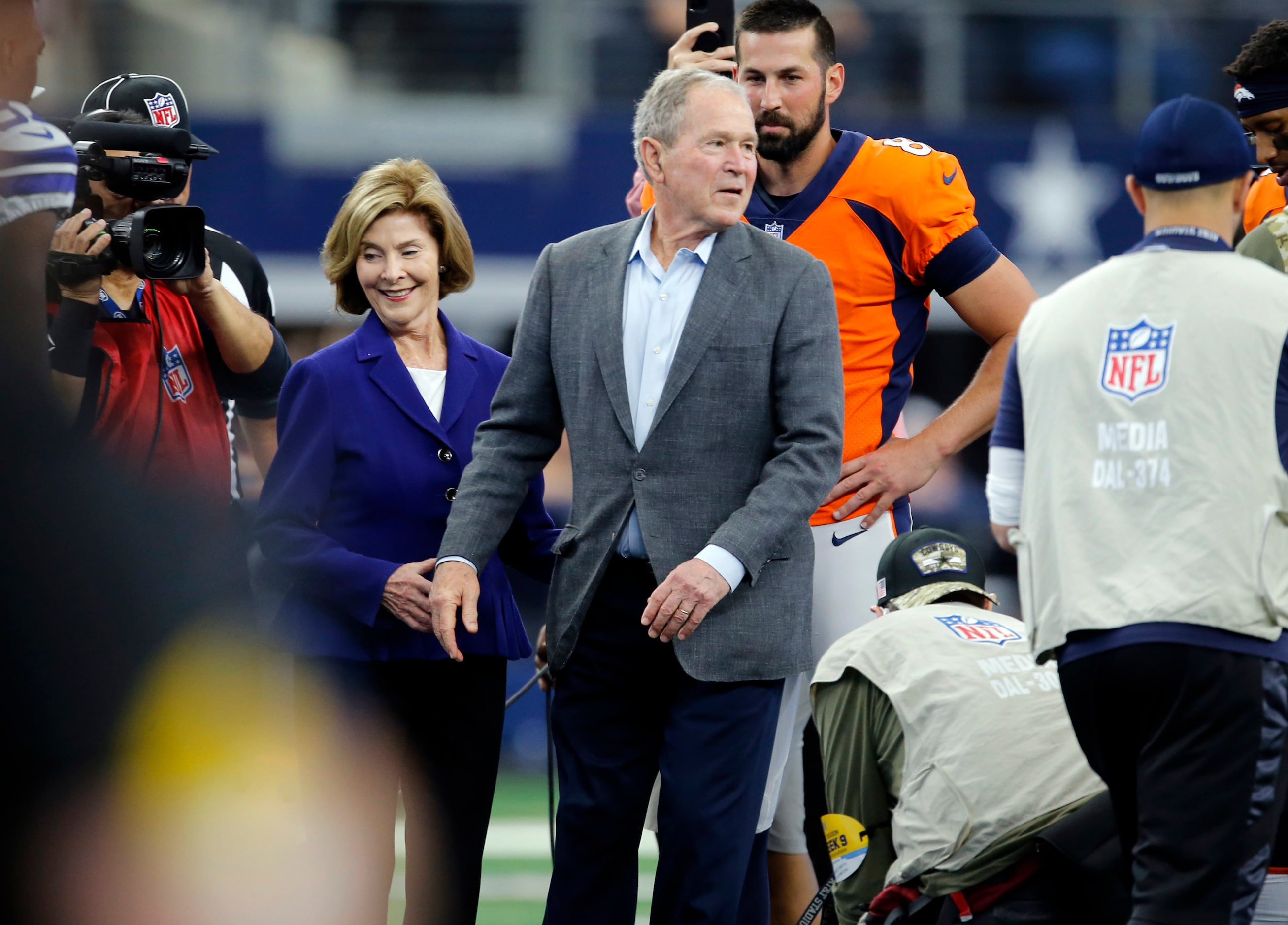 Former President of the United States George W. Bush and wife Laura navigate media,...