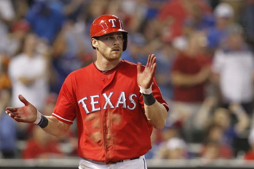 Texas Rangers center fielder Craig Gentry (23) reacts after he scored a run on a hit by by...