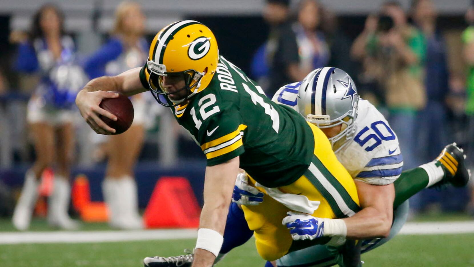 Green Bay Packers quarterback Aaron Rodgers (12) is tackled by Dallas Cowboys outside...