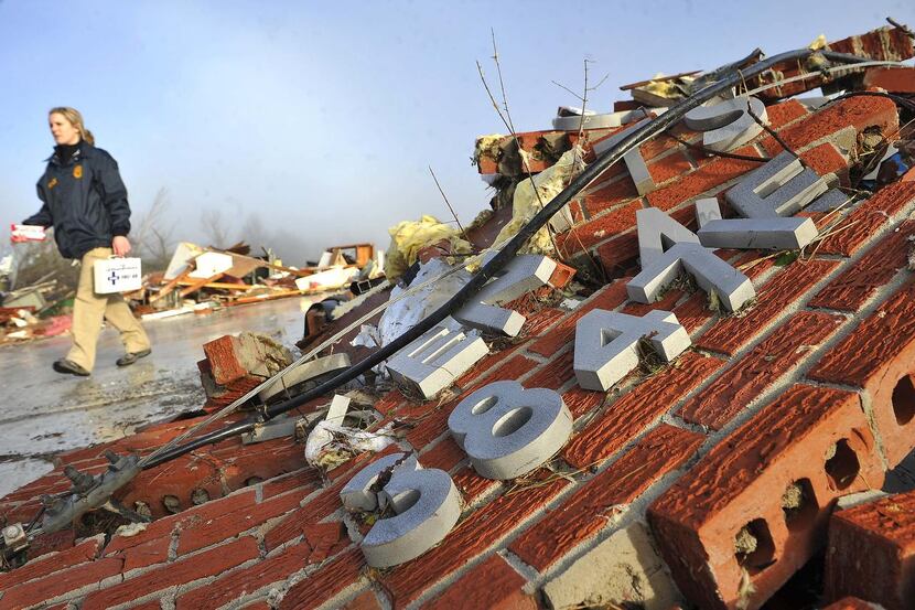 
A postal worker walked by the rubble of the Lutts, Tenn., post office after a rare December...