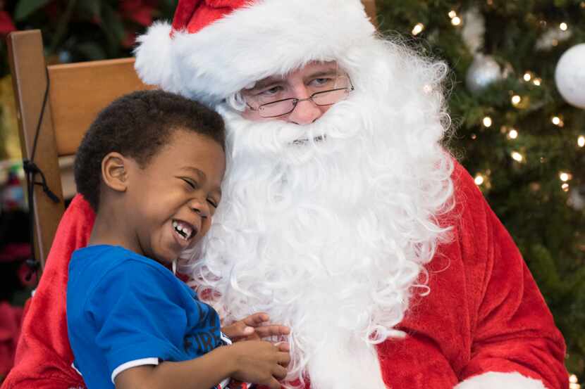 Darrian Fletcher, 5, sits in Santa's lap during the Rainbow Days Saturday with Santa at...