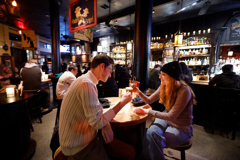 On a cold rainy winter night, bar patrons Brandon Maahs and Cori Booker toast their hot...