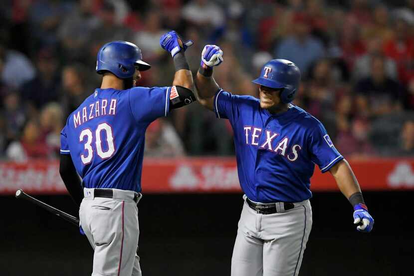 Texas Rangers' Adrian Beltre, right, is congratulated by Nomar Mazara after hitting a solo...