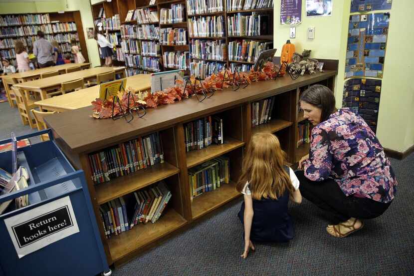 
Librarian Robin Pattillo helps a student find a book in the Lakewood Elementary School...