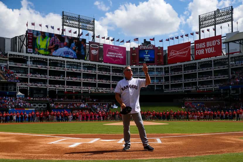 Former Texas Rangers player  Kenny Rogers waves to fans as he is introduced to catch the...