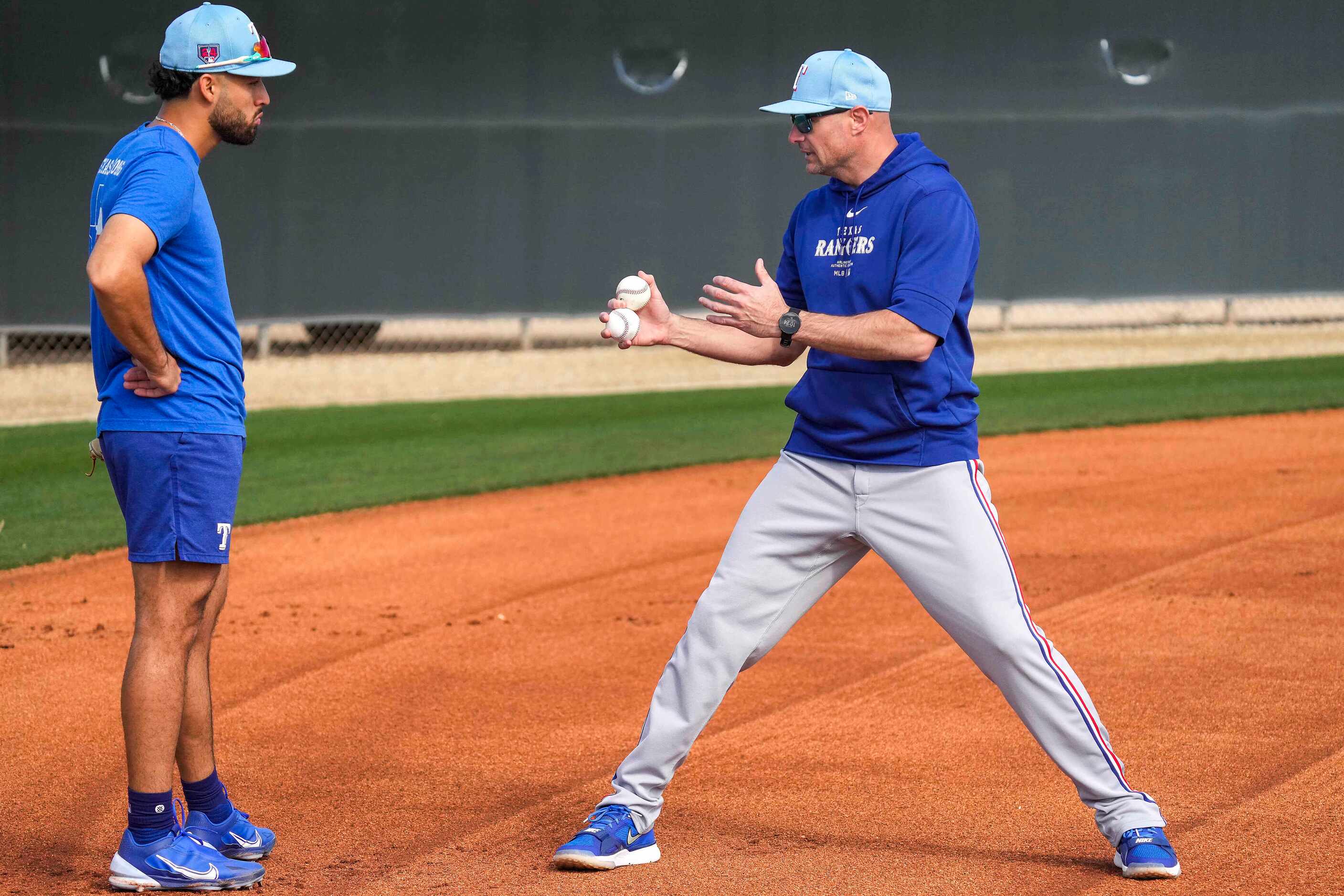 Texas Rangers first base coach Corey Ragsdale works with infielder Jonathan Ornelas during a...