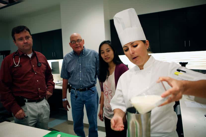 Chef Zoe Muller prepares a smoothie for cancer patient Kevin McKool (center) as oncology...