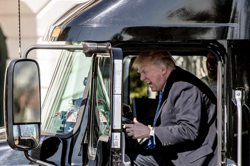 President Donald Trump pretends to drive as he gets in an 18-wheeler as he meets with...