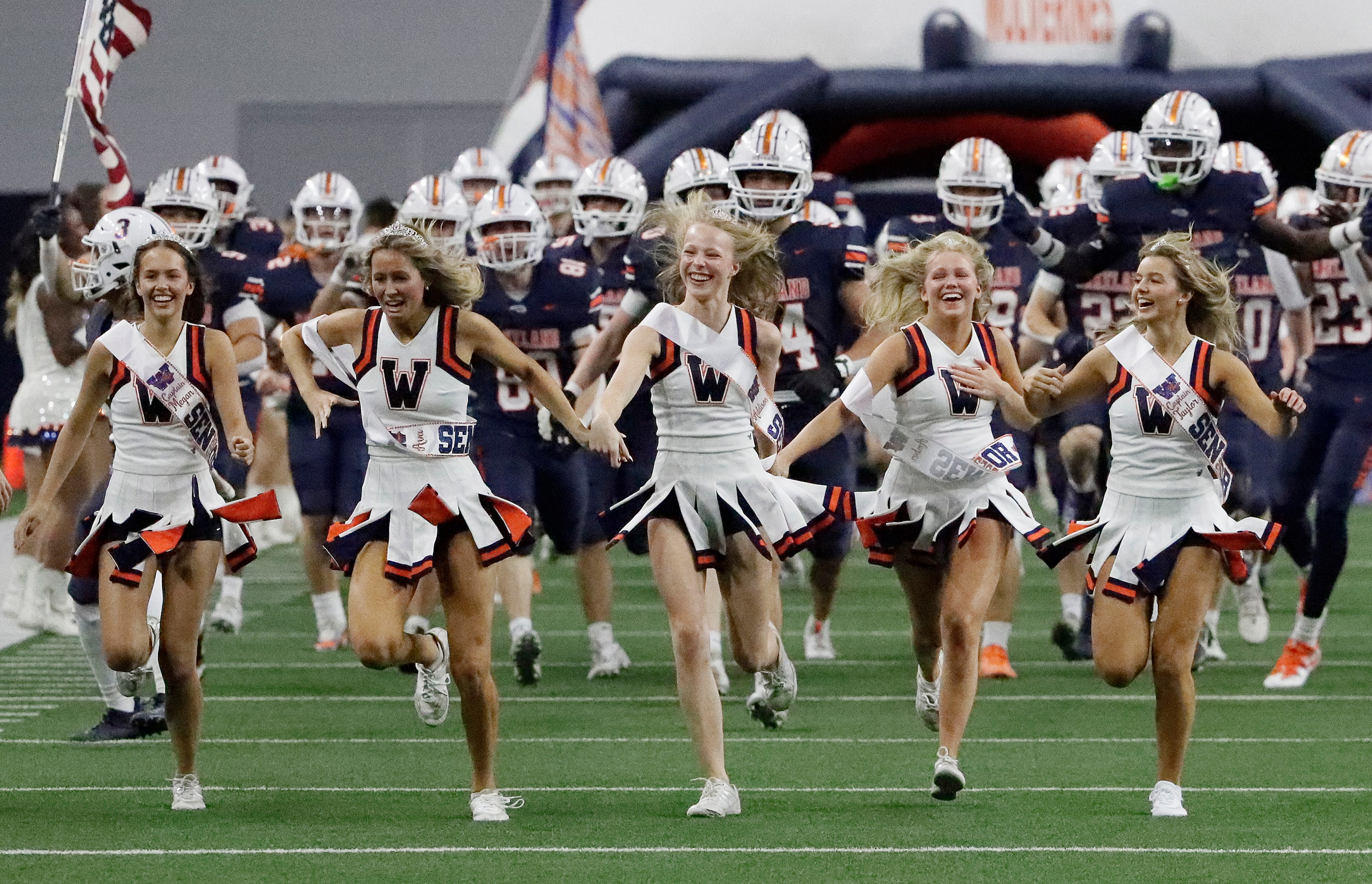 Wakeland High School cheerleaders lead the team onto the field before kickoff as Wakeland...