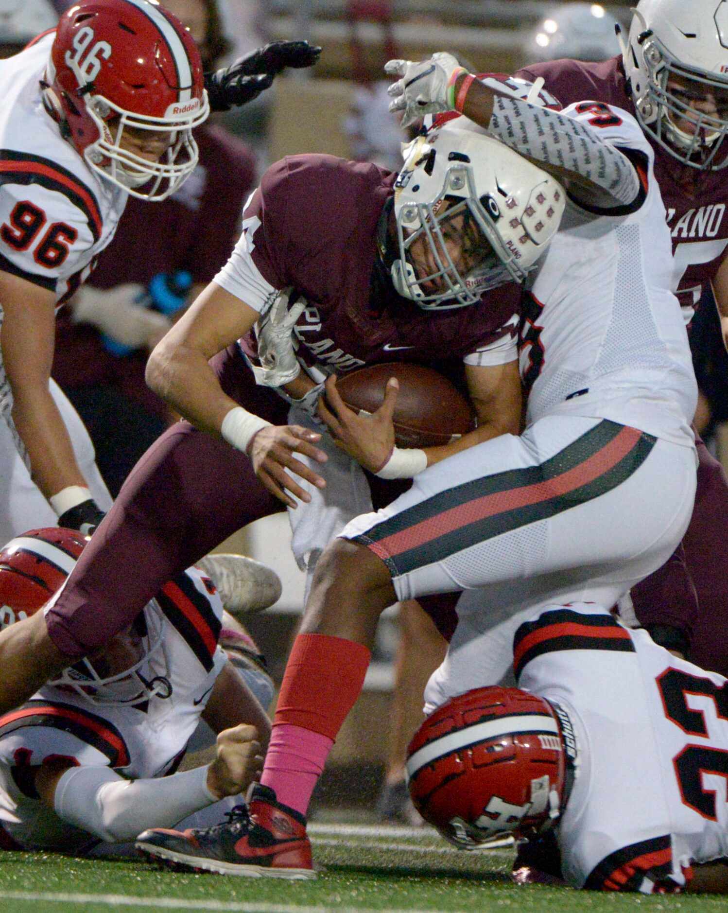 Plano’s Oliver Towns is tackled by Lake Highlands Jeremiah Richards (3) in the first quarter...