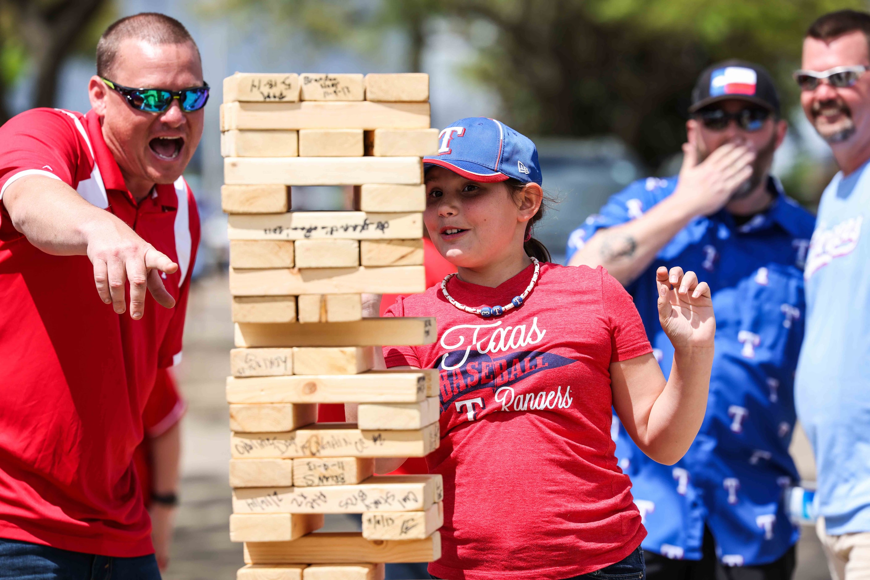 Jeremy Watts, left, and Skylar Watts, 11, play Jenga outside the Globe Life Field before the...