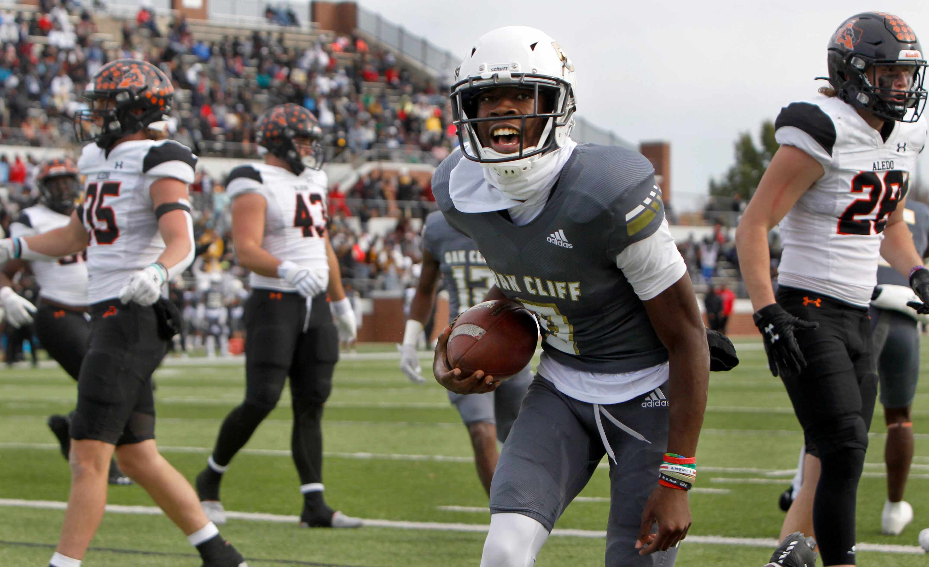 South Oak Cliff quarterback Kevin Henry-Jennings (8) lets out a yell leaving Aledo defenders...