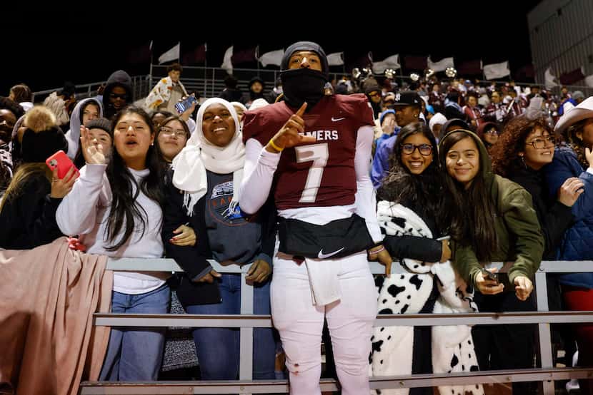 Lewisville quarterback Ethan Terrell (7) celebrates a win over Allen with fellow students...