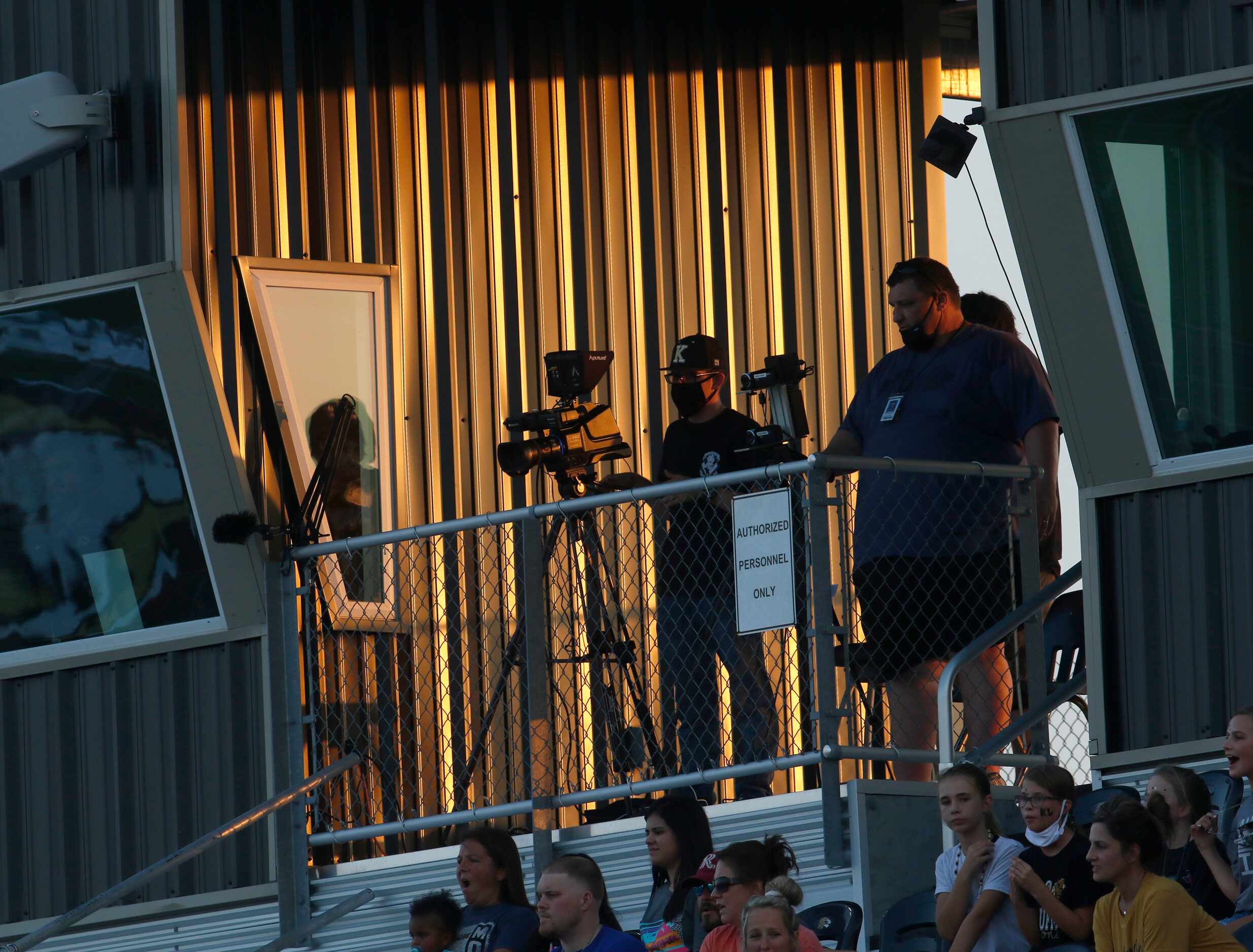 A group of videographers prepare to record the opening kickoff from the press box level....