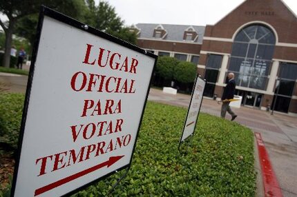 A sign in Spanish points toward City Hall in Farmers Branch, indicating an early voting...