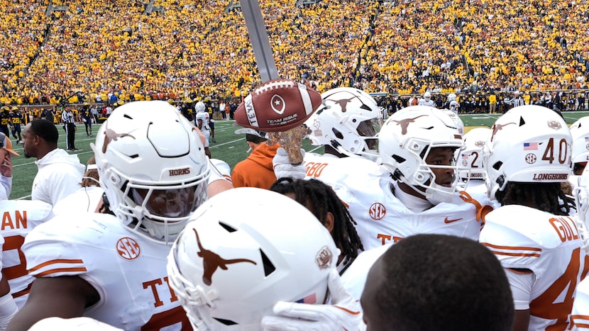 Texas defensive back Andrew Mukuba celebrates his interception with the turnover sword...