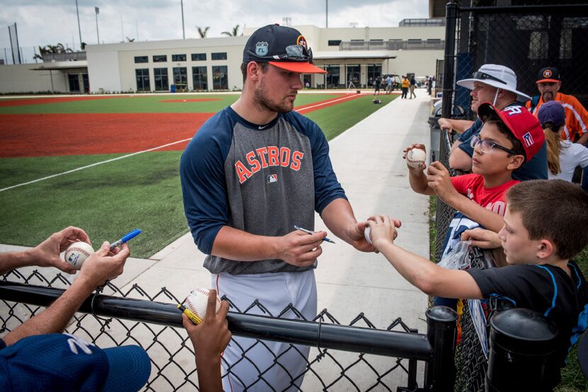 Houston Astros third baseman J.D. Davis signs baseballs for fans  at spring training at the...