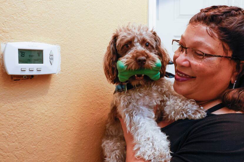 DeSoto resident Avery Anderson, 58, and her puppy Beignet by the thermostat at her home on...