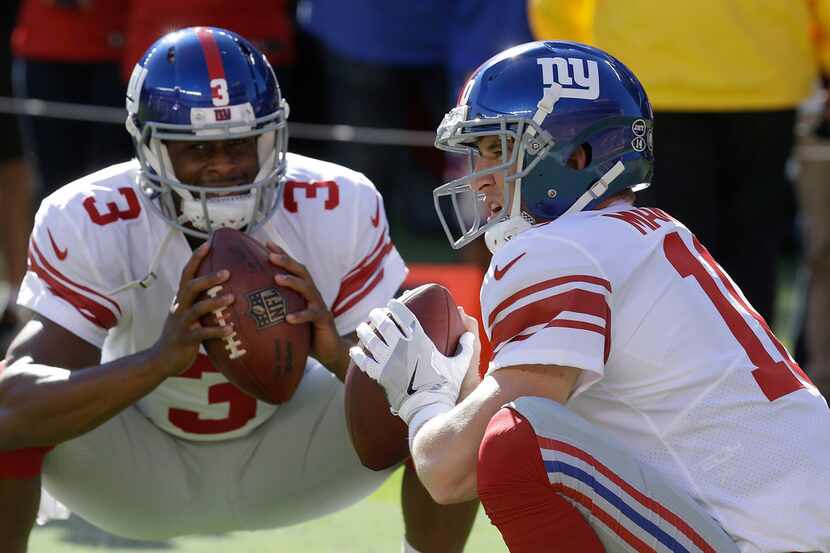 New York Giants quarterbacks Eli Manning (10) and Eli Manning warm up before an NFL football...