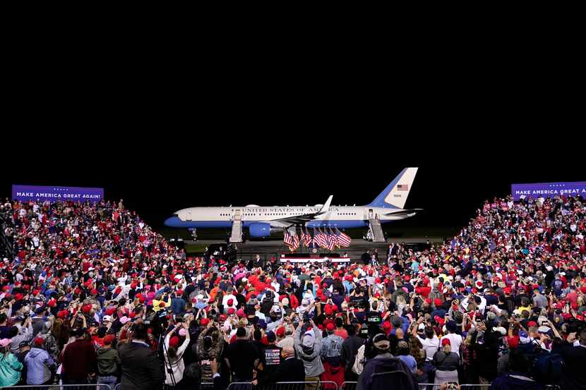 With Air Force One behind him, President Donald Trump campaigns at a rally that drew...