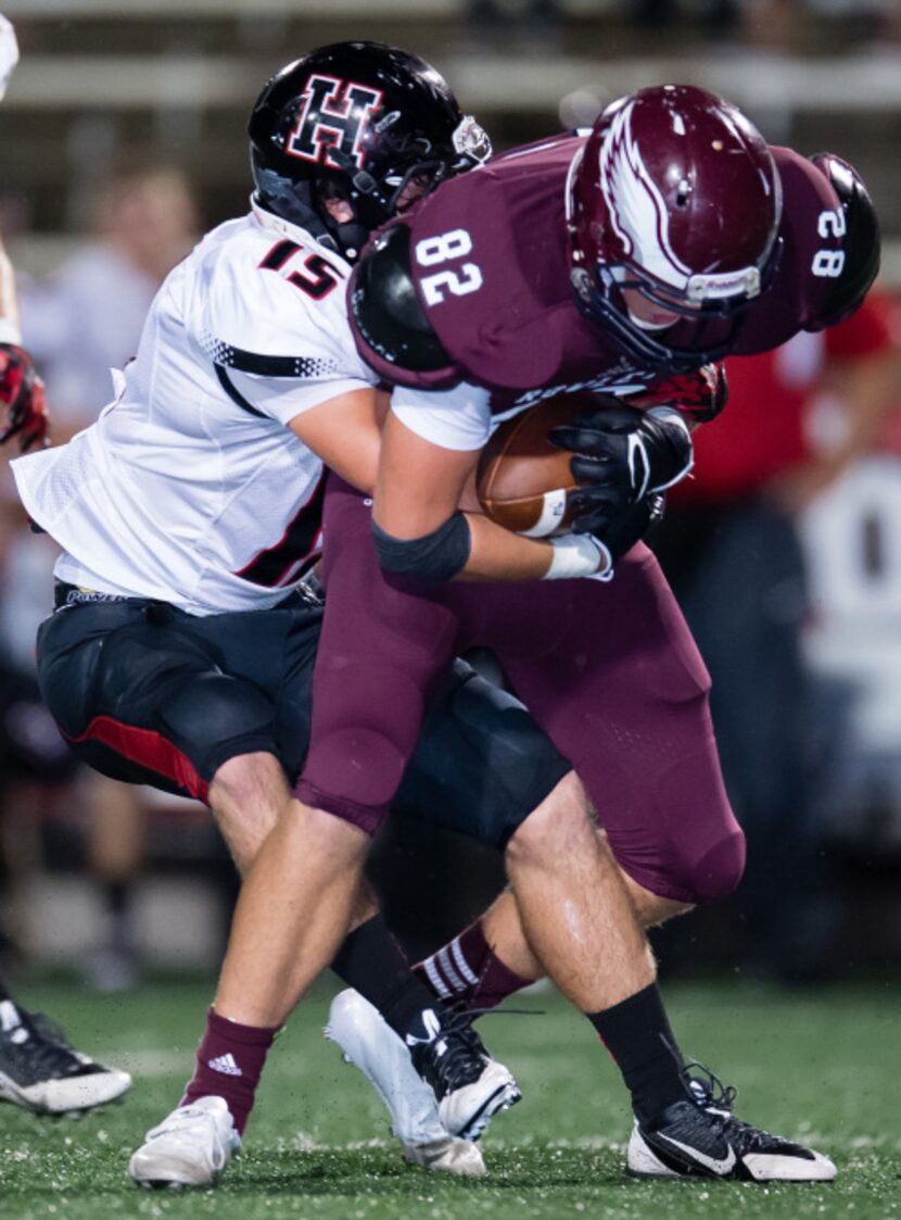 Rockwall-Heath defensive back  Ryan Todd (15) tackles Rowlett receiver James Moates (82)...