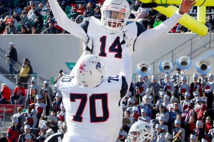 Allen quarterback Grant Tisdale (14) is hoisted in the end zone by teammate Trey Stratford...