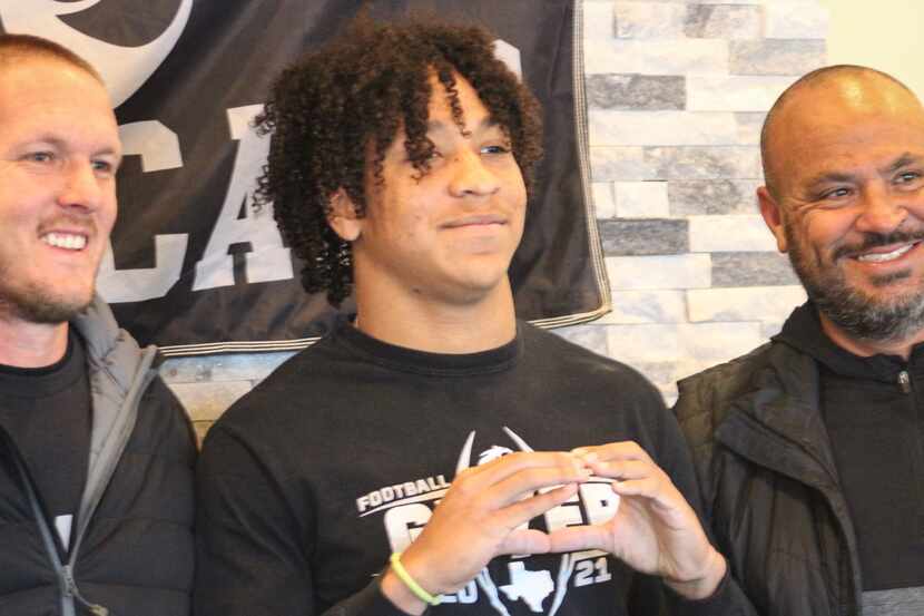 Denton Guyer five-star safety Peyton Bowen poses with coaches after he signed his national...
