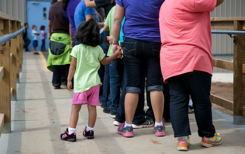 Residents line up to eat lunch at the  South Texas Family Residential Center that houses...