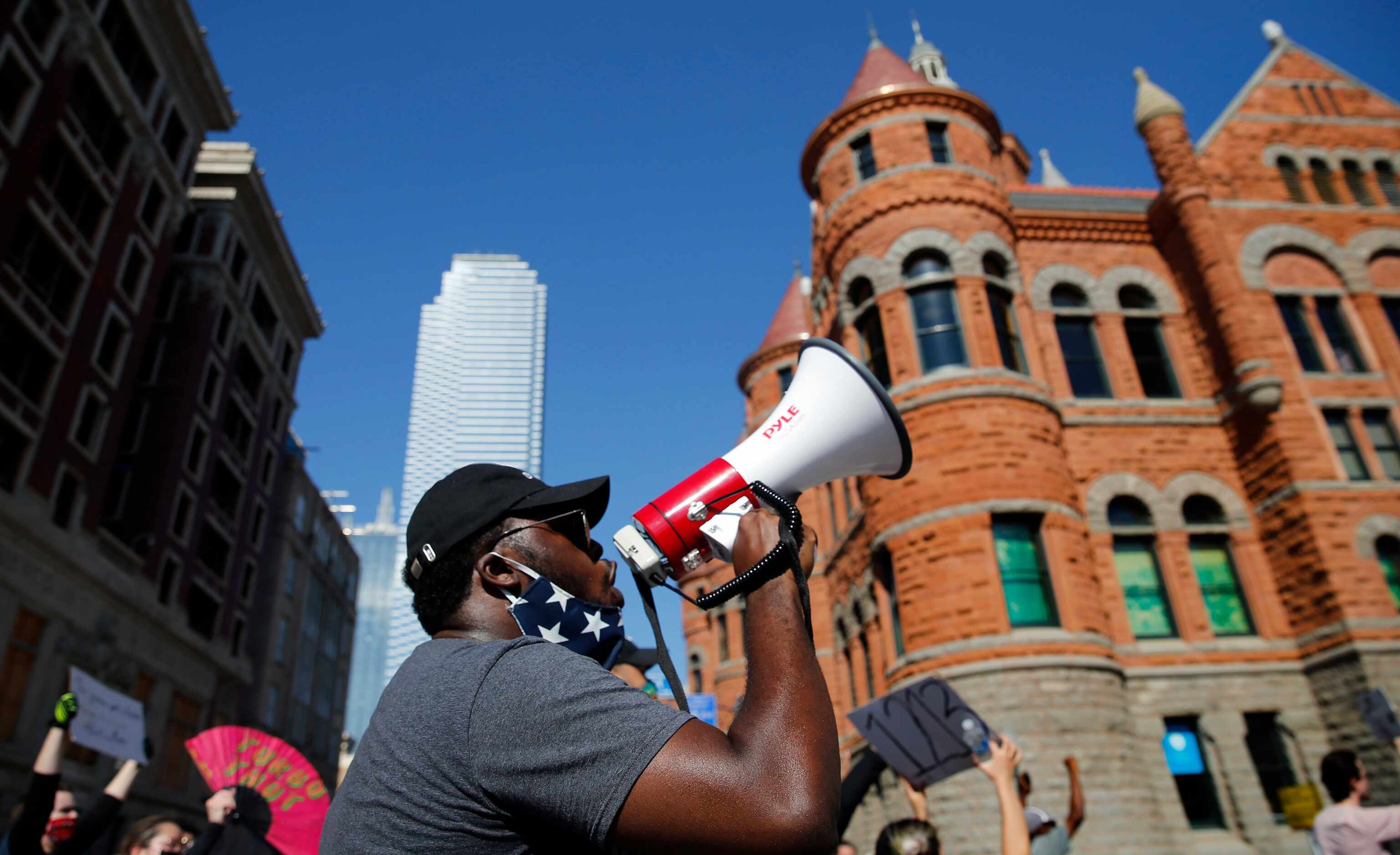 With his bullhorn, Edmund Simpson II of Dallas leads protestors in a chant as the group...