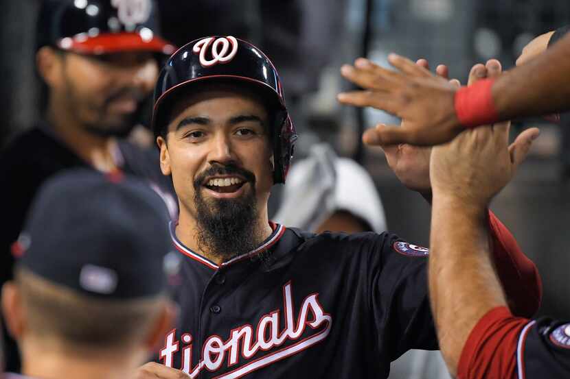 Washington Nationals' Anthony Rendon celebrates in the dugout after scoring on a single by...