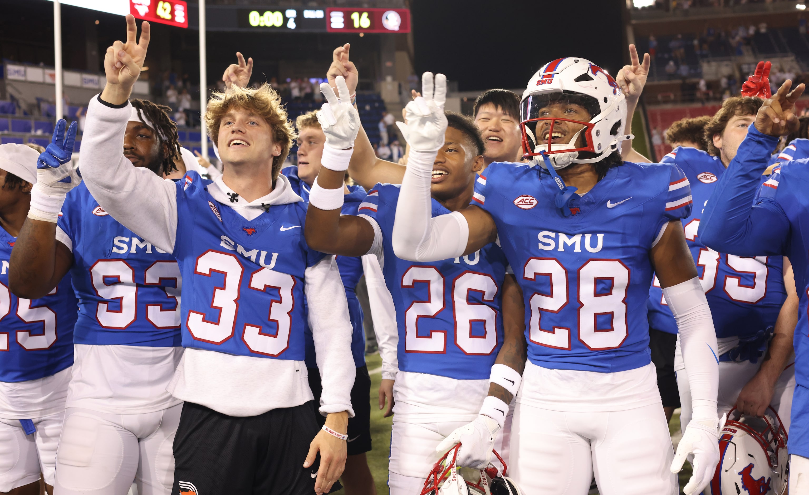 SMU Mustangs players pause for the playing of the school song following the teams' 42-16...