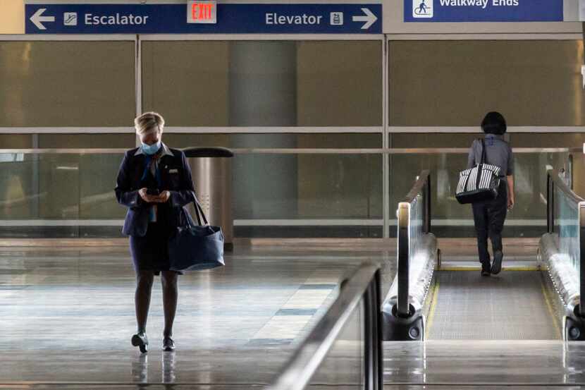 An airlines employee walks out of Terminal D at DFW International Airport in Irving, Texas,...