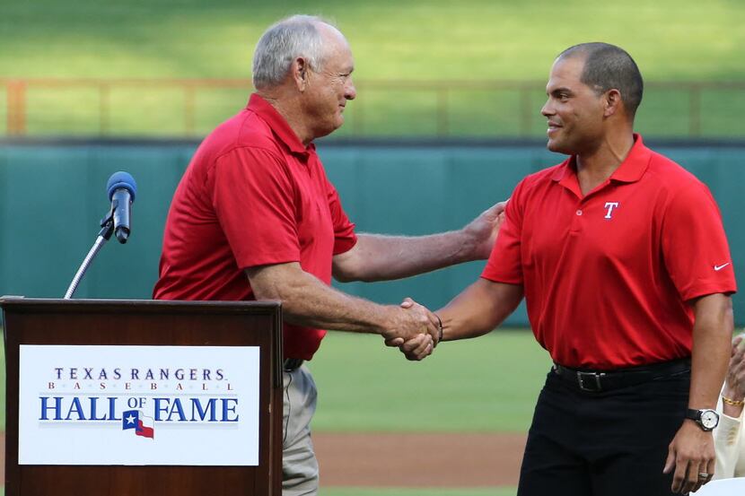 Former Texas catcher Ivan "Pudge" Rodriguez gets a handshake from Rangers CEO Nolan Ryan as...