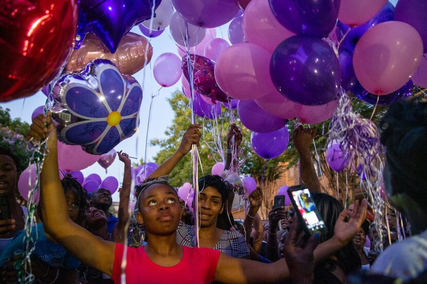 Sontravia Elder (center) prepares to release balloons at a vigil honoring the life of her...