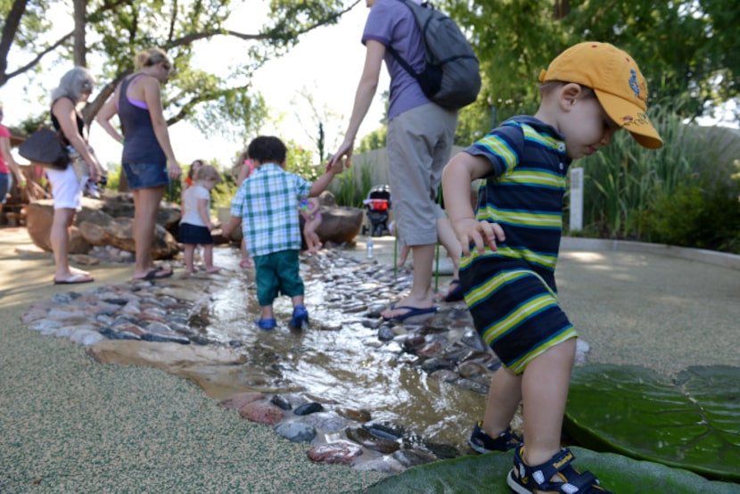 Rory Cruise plays in the simulated trail bed that runs through the Rory Meyers Children's...