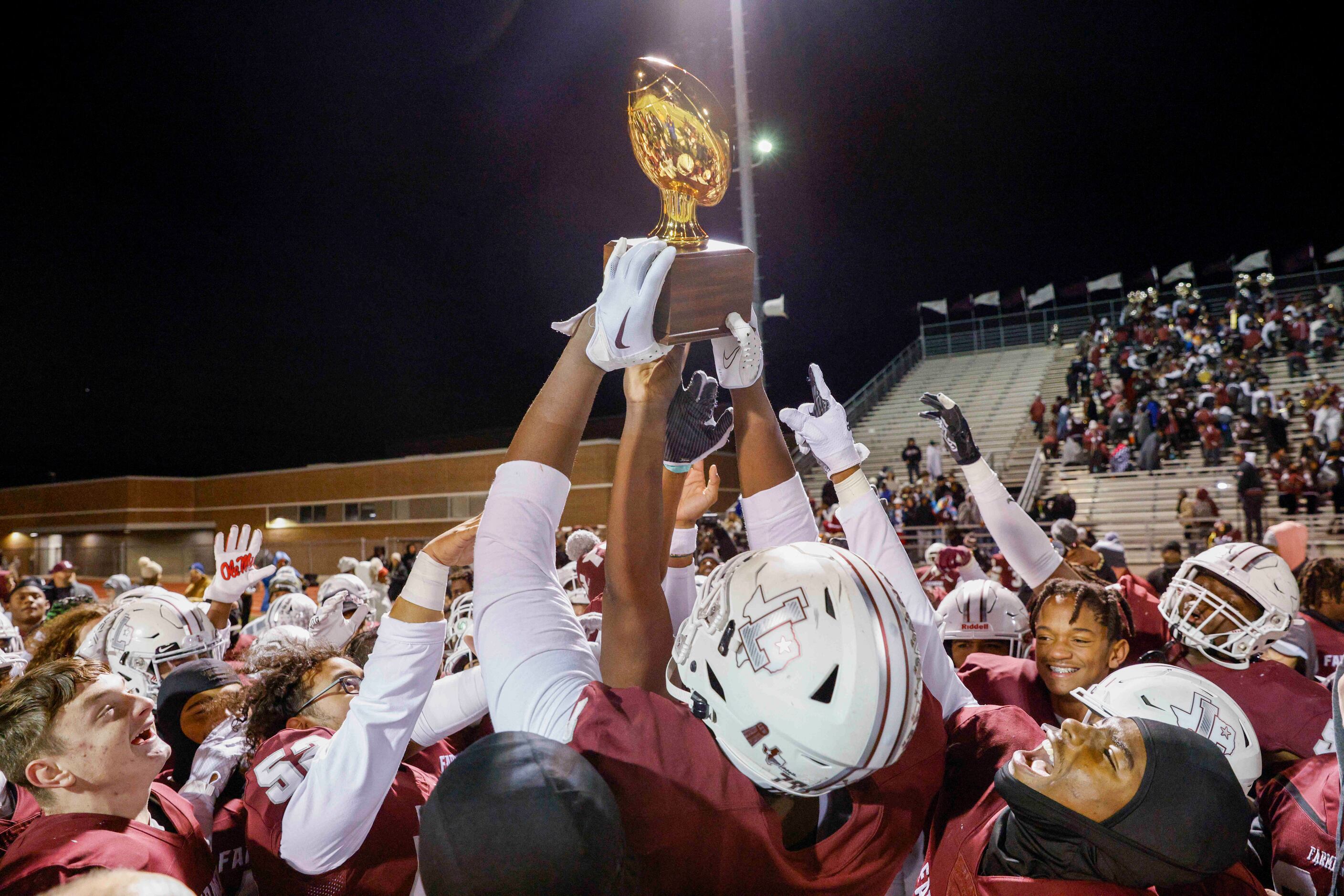 Lewisville players raise a Class 6A bi-district championship trophy after defeating Allen at...