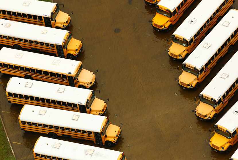 A yard full of school buses sit in receding flood water at Sheldon ISD near Houston, Texas,...