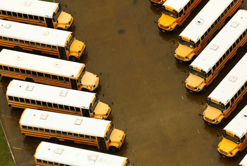 A yard full of school buses sit in receding flood water at Sheldon ISD near Houston, Texas,...