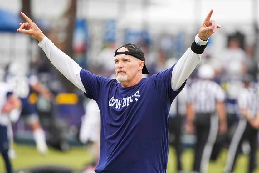 Dallas Cowboys defensive coordinator Dan Quinn motions to players during a practice at...
