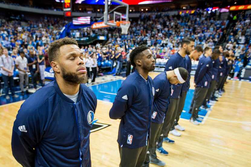 Dallas Mavericks guard Justin Anderson stands with teammates for the national anthem before...