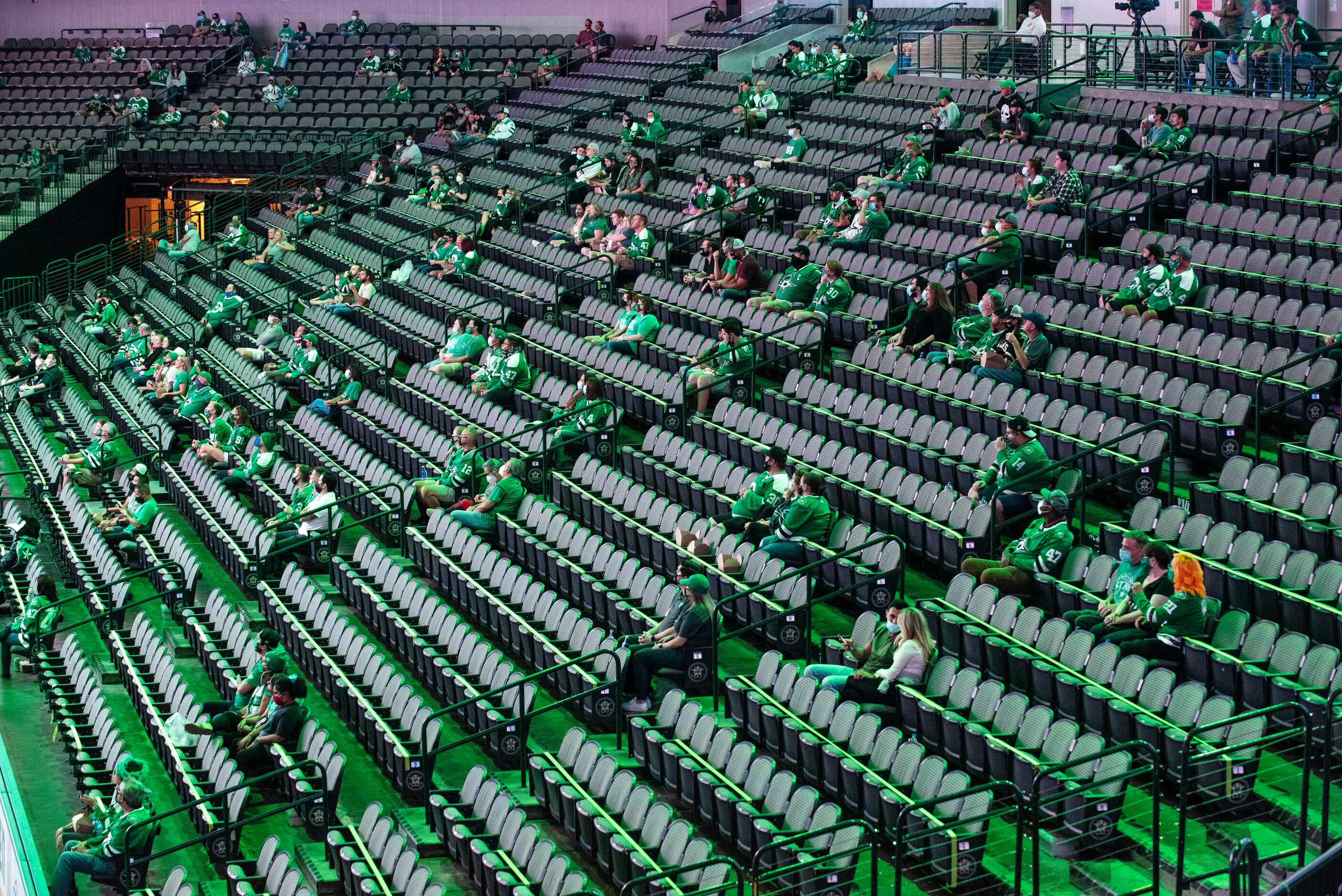 Fans sit in social distance sections as they wait for the start of period 2 during a watch...