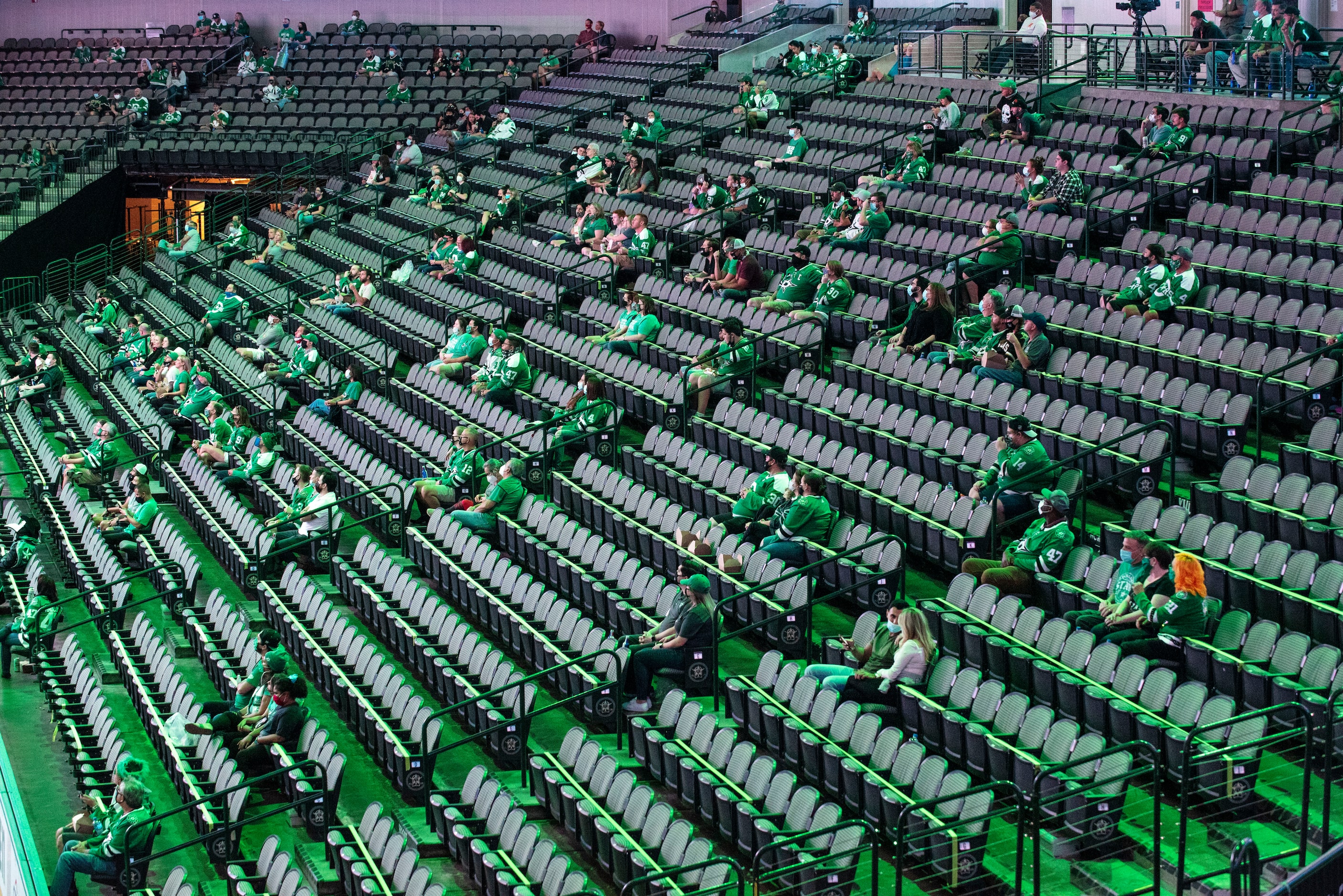 Fans sit in social distance sections as they wait for the start of period 2 during a watch...