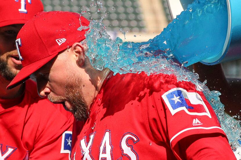 Texas Rangers relief pitcher Shawn Kelley (27) reacts as he gets doused with sports drink...